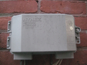 A common demarc box mounted outside on a brick wall.