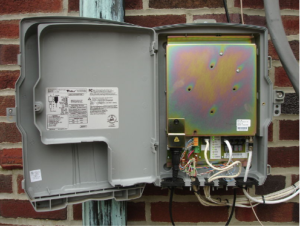An open ONT (Optical Network Terminal) box mounted outside on a brick wall